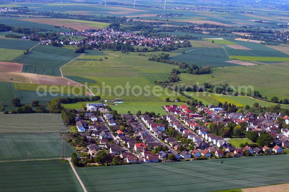Aerial image Bauernheim - Agricultural land and field borders surround the settlement area of the village in Bauernheim in the state Hesse, Germany