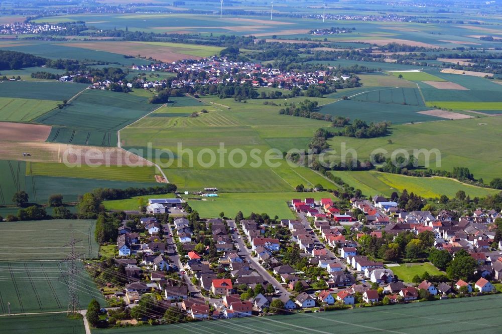 Aerial photograph Bauernheim - Agricultural land and field borders surround the settlement area of the village in Bauernheim in the state Hesse, Germany