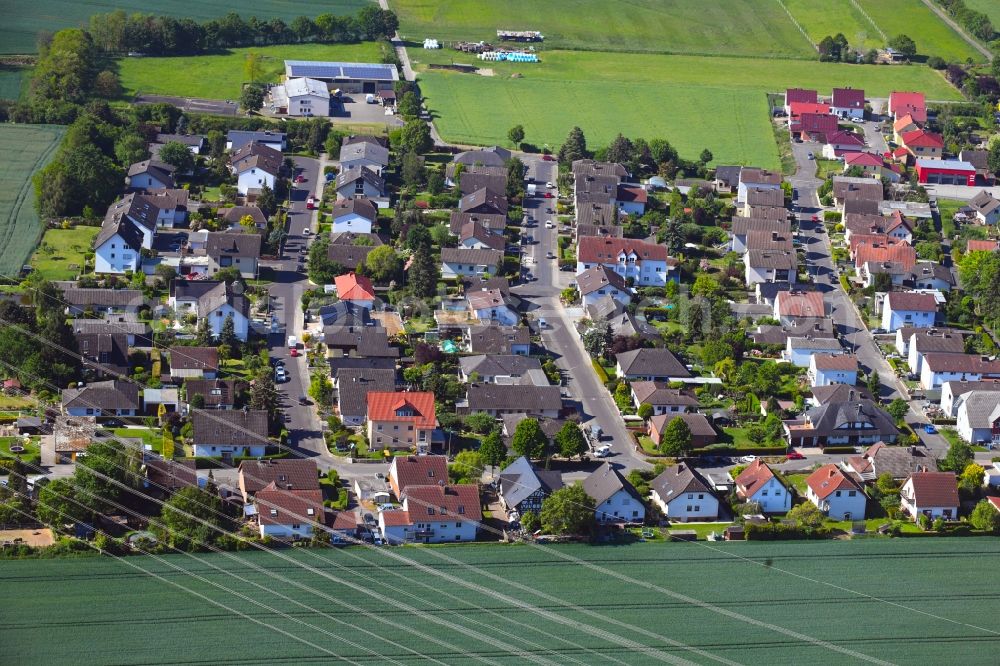 Bauernheim from the bird's eye view: Agricultural land and field borders surround the settlement area of the village in Bauernheim in the state Hesse, Germany