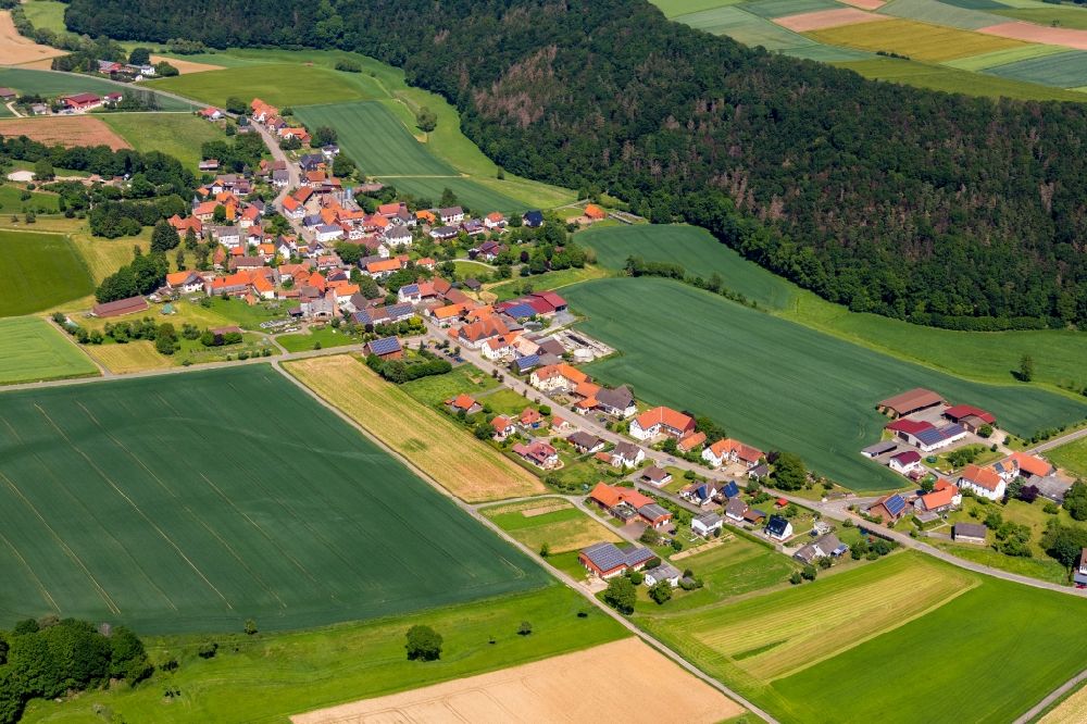 Böhne from above - Agricultural land and field borders surround the settlement area of the village in Boehne in the state Hesse, Germany