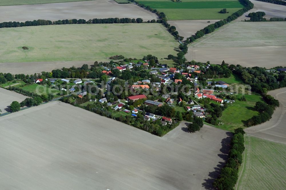 Brügge from above - Agricultural land and field borders surround the settlement area of the village in Bruegge in the state Brandenburg, Germany