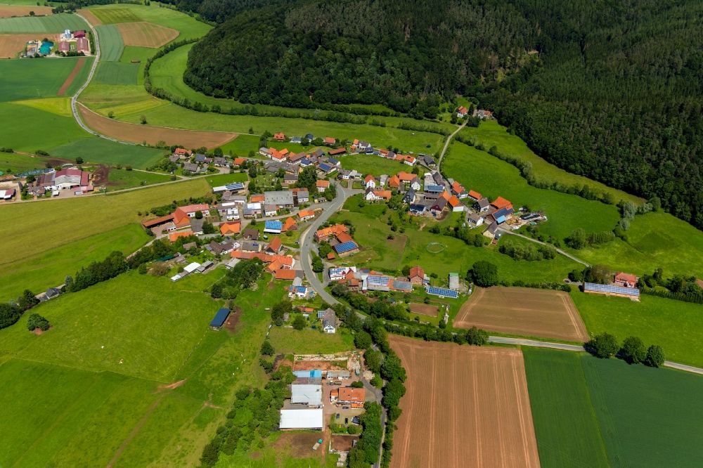 Dehringhausen from above - Agricultural land and field borders surround the settlement area of the village in Dehringhausen in the state Hesse, Germany