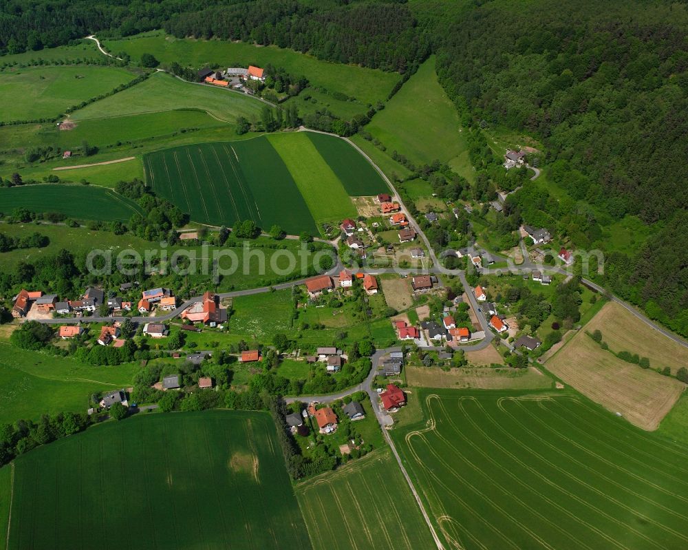 Aerial photograph Atzelrode - Agricultural land and field boundaries surround the settlement area of the village in Atzelrode in the state Hesse, Germany
