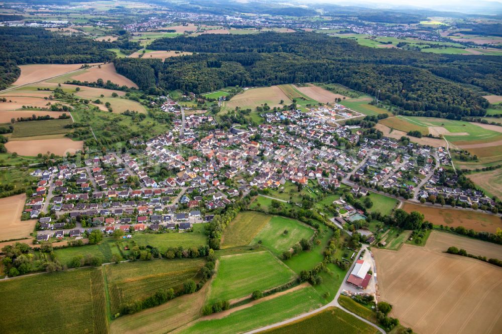 Büchig from above - Agricultural land and field boundaries surround the settlement area of the village in Buechig in the state Baden-Wuerttemberg, Germany