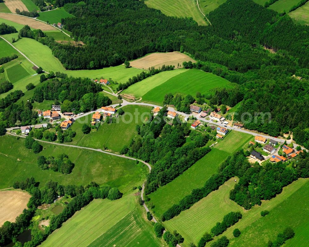 Bernhardsberg from the bird's eye view: Agricultural land and field boundaries surround the settlement area of the village in Bernhardsberg in the state Bavaria, Germany