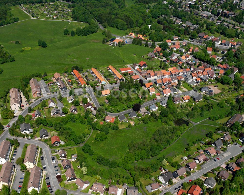 Clausthal-Zellerfeld from the bird's eye view: Agricultural land and field boundaries surround the settlement area of the village in Clausthal-Zellerfeld in the state Lower Saxony, Germany