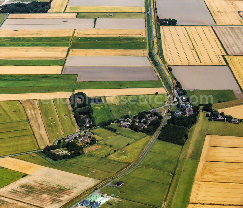 Aerial image Dagebüll - Agricultural land and field boundaries on the K91 village road from Dagebuell church surround the settlement area of the village in Dagebuell North Friesland in the state Schleswig-Holstein, Germany