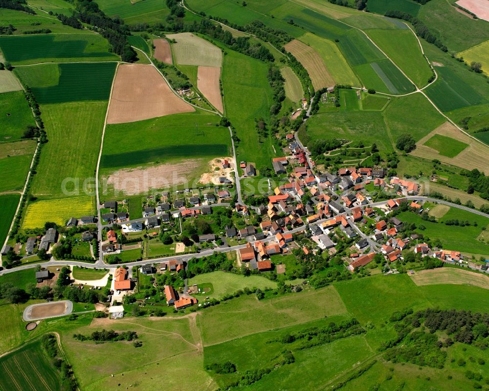 Erkshausen from the bird's eye view: Agricultural land and field boundaries surround the settlement area of the village in Erkshausen in the state Hesse, Germany