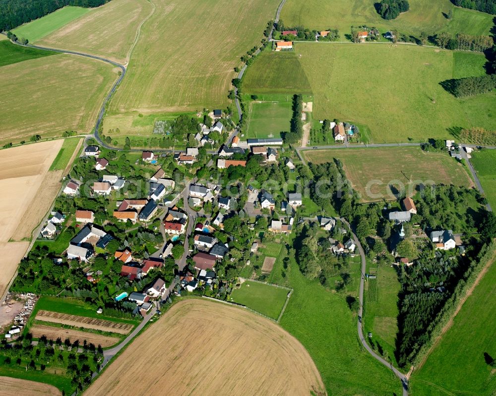 Großmilkau from the bird's eye view: Agricultural land and field boundaries surround the settlement area of the village in Großmilkau in the state Saxony, Germany