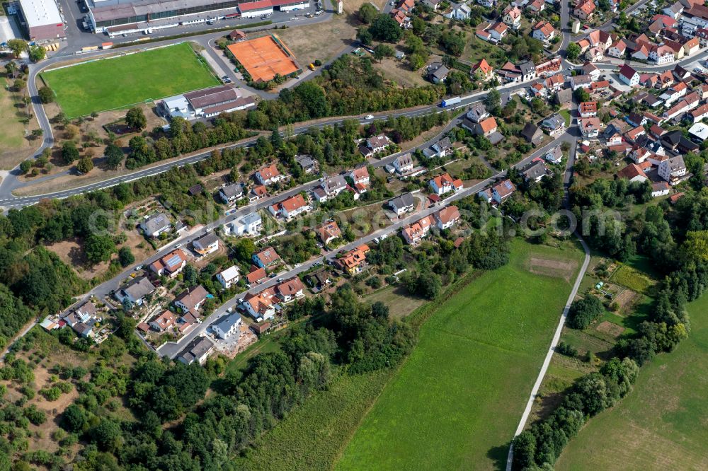 Gössenheim from above - Agricultural land and field boundaries surround the settlement area of the village in Gössenheim in the state Bavaria, Germany
