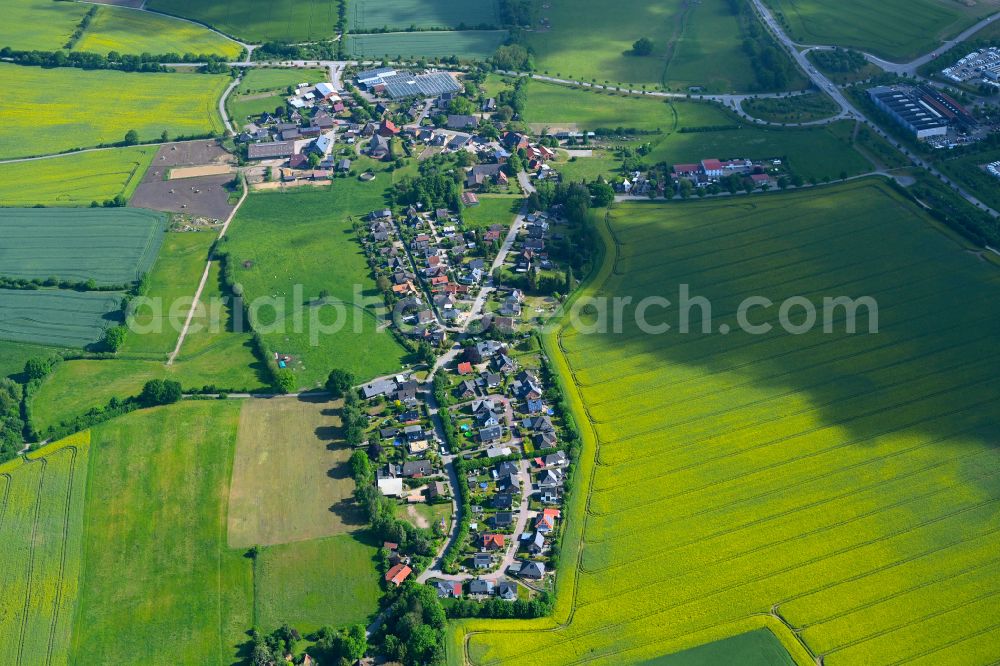Aerial image Harmsdorf - Agricultural land and field boundaries surround the settlement area of the village in Harmsdorf in the state Schleswig-Holstein, Germany