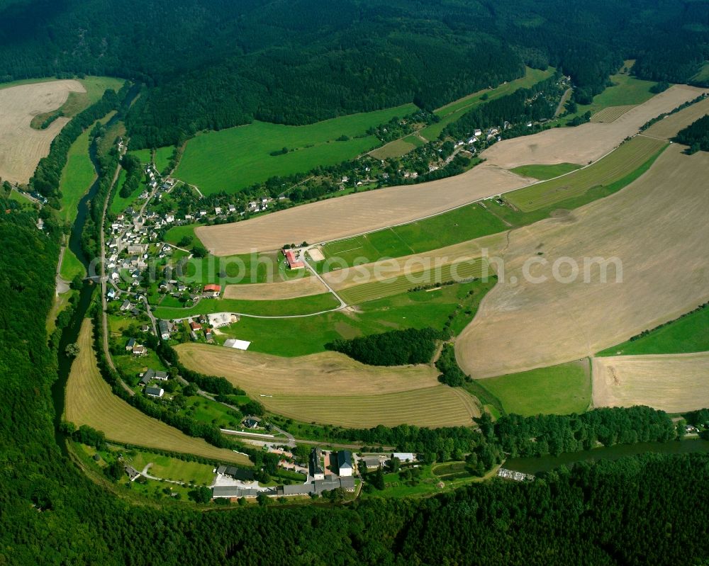 Hennersdorf from above - Agricultural land and field boundaries surround the settlement area of the village in Hennersdorf in the state Saxony, Germany