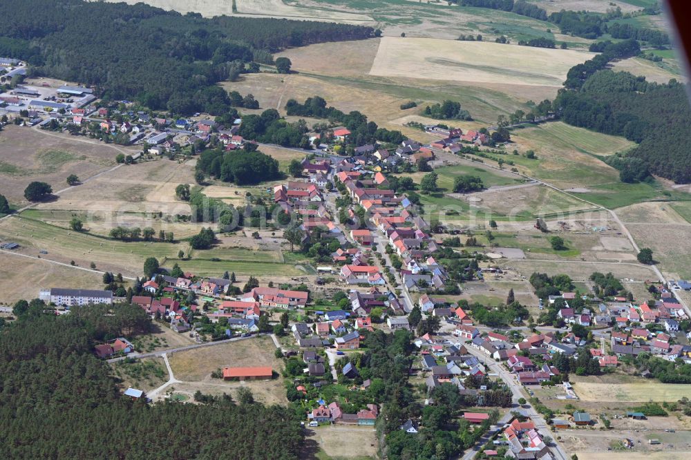 Hennickendorf from above - Agricultural land and field boundaries surround the settlement area of the village in Hennickendorf in the state Brandenburg, Germany