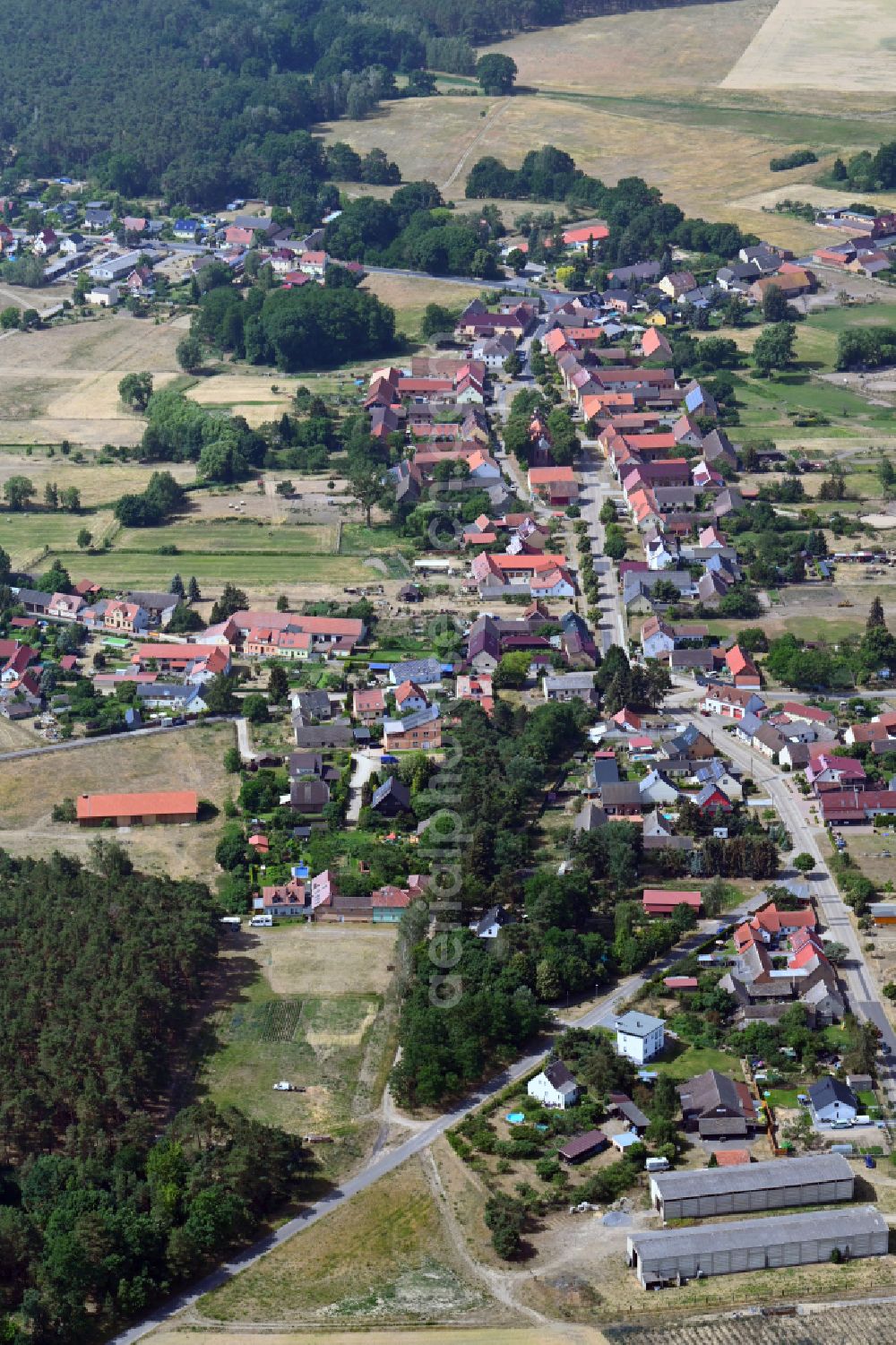 Hennickendorf from the bird's eye view: Agricultural land and field boundaries surround the settlement area of the village in Hennickendorf in the state Brandenburg, Germany