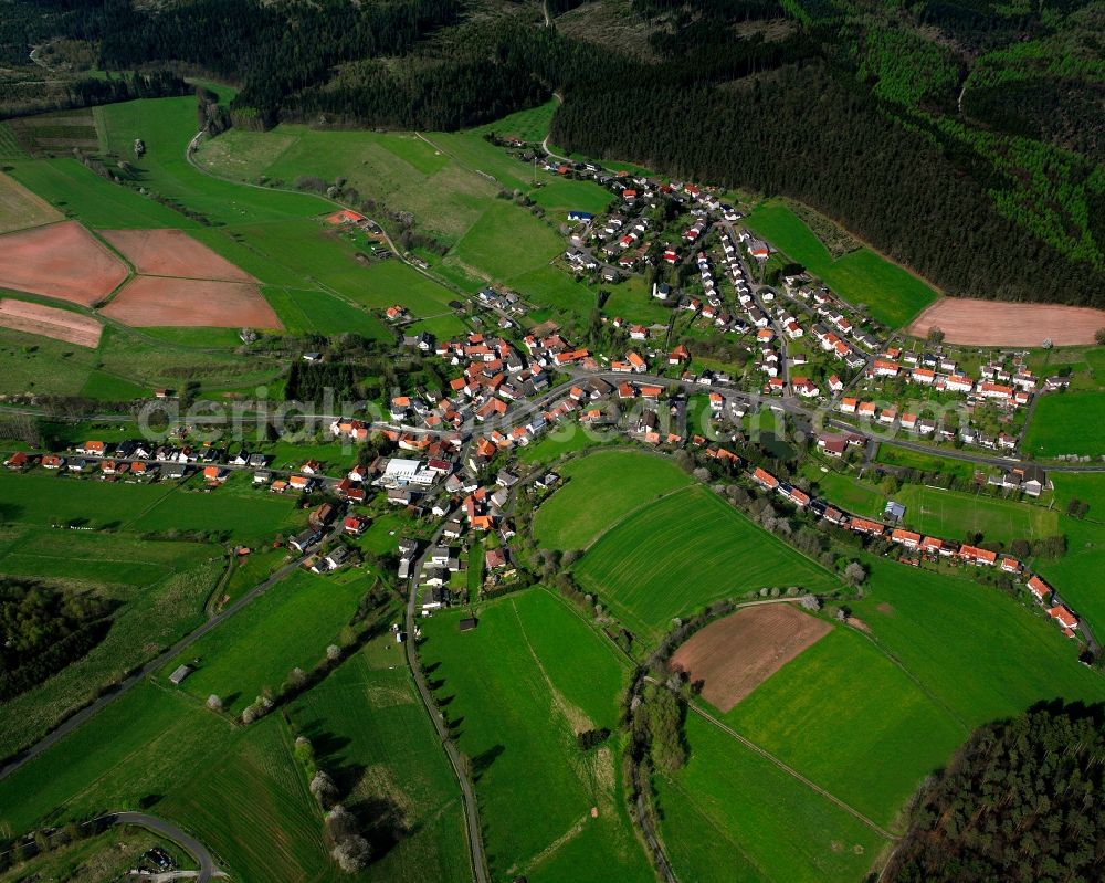 Herfa from above - Agricultural land and field boundaries surround the settlement area of the village in Herfa in the state Hesse, Germany