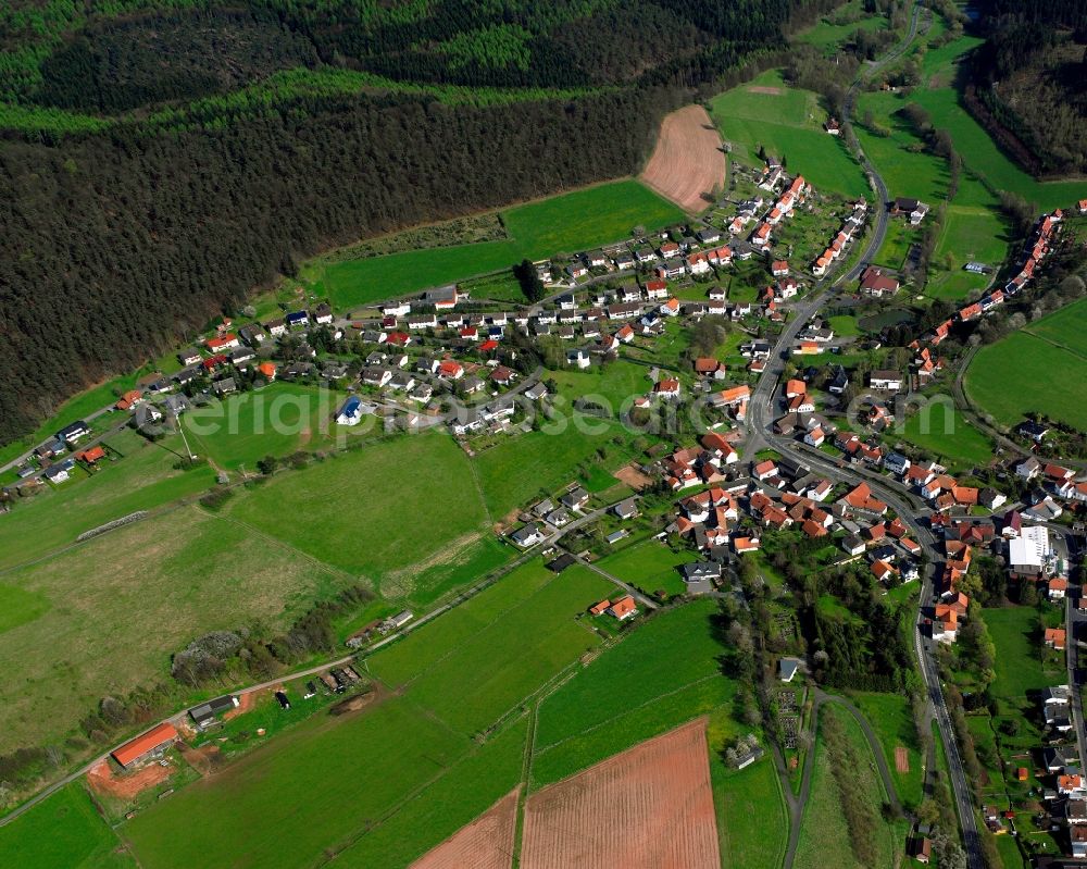 Herfa from the bird's eye view: Agricultural land and field boundaries surround the settlement area of the village in Herfa in the state Hesse, Germany