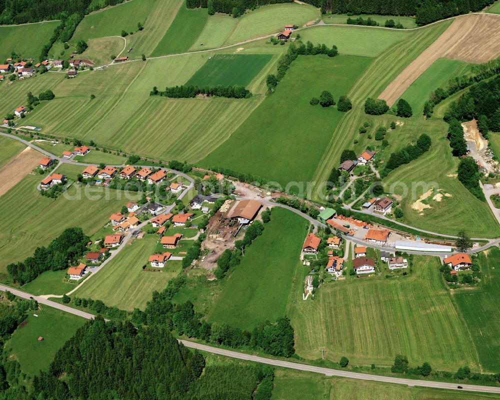 Karlsbach from the bird's eye view: Agricultural land and field boundaries surround the settlement area of the village in Karlsbach in the state Bavaria, Germany