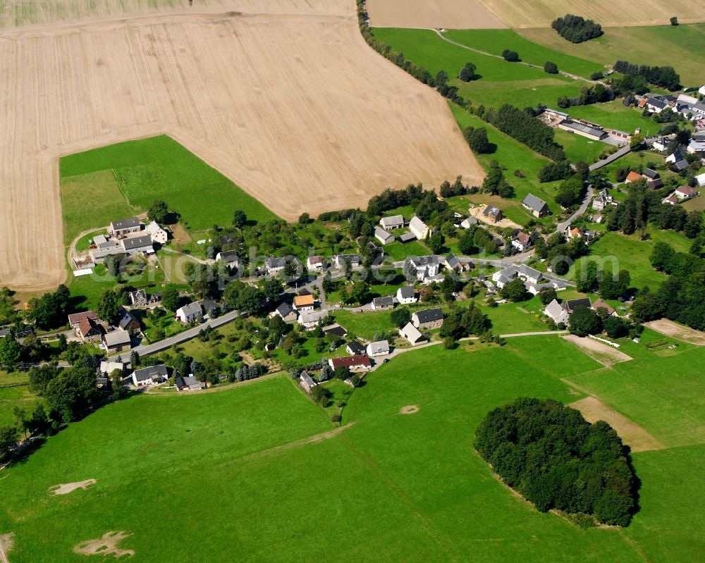 Kleinhartmannsdorf from the bird's eye view: Agricultural land and field boundaries surround the settlement area of the village in Kleinhartmannsdorf in the state Saxony, Germany