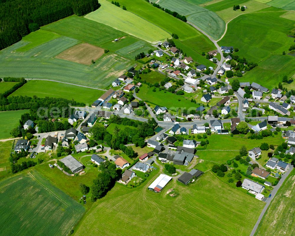 Kleinschwarzenbach from above - Agricultural land and field boundaries surround the settlement area of the village in Kleinschwarzenbach in the state Bavaria, Germany