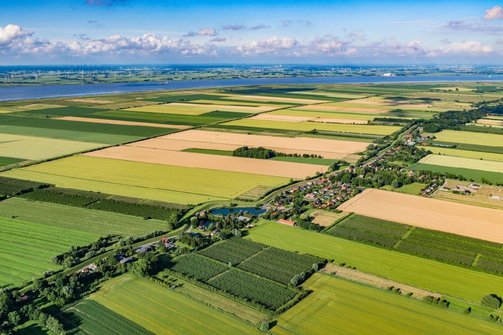 Krummendeich from above - Agricultural land and field boundaries surround the settlement area of the village in Krummendeich in the state Lower Saxony, Germany