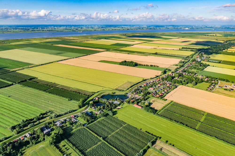 Krummendeich from the bird's eye view: Agricultural land and field boundaries surround the settlement area of the village in Krummendeich in the state Lower Saxony, Germany
