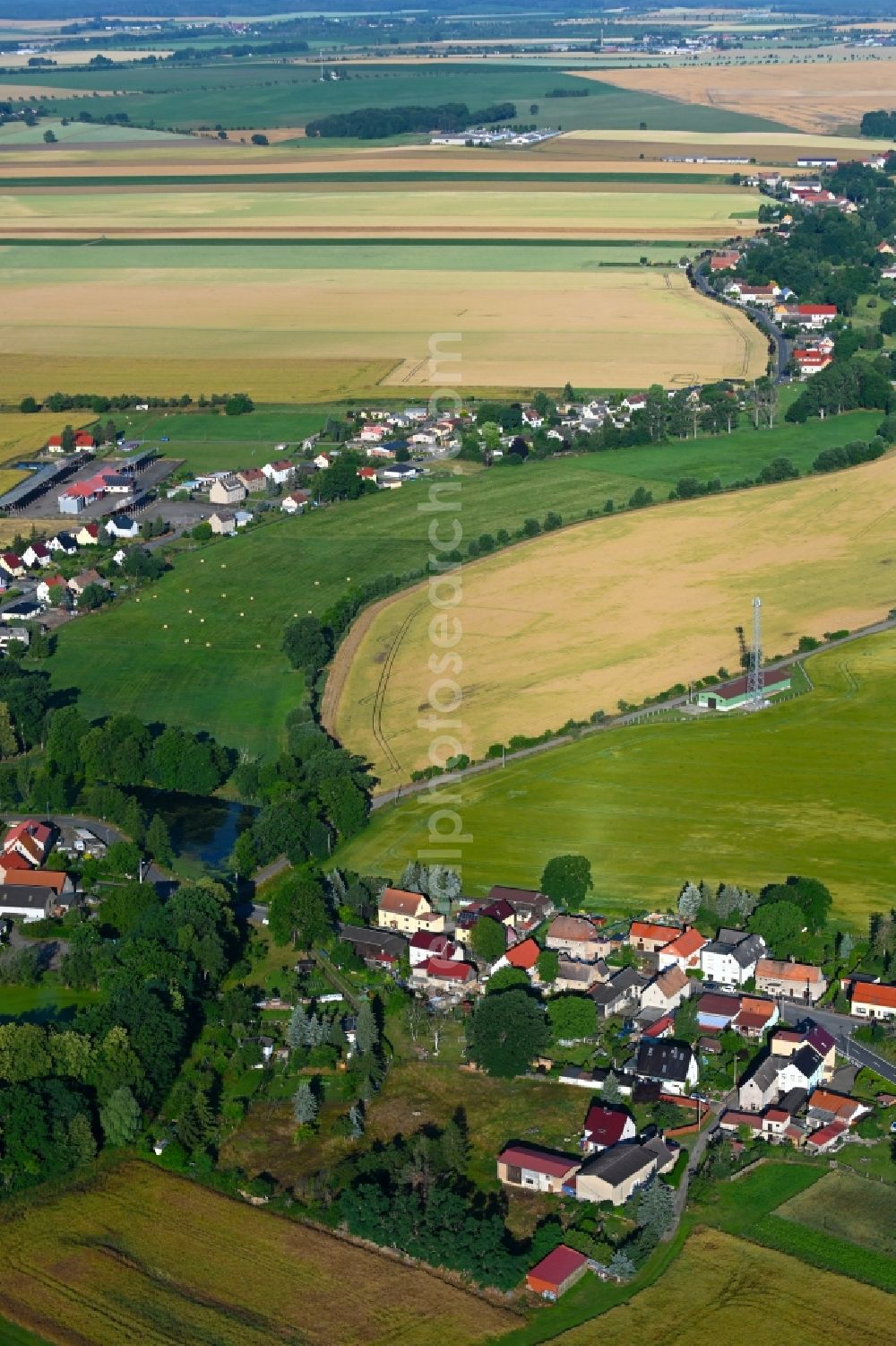 Lampertswalde from above - Agricultural land and field boundaries surround the settlement area of the village in Lampertswalde in the state Saxony, Germany
