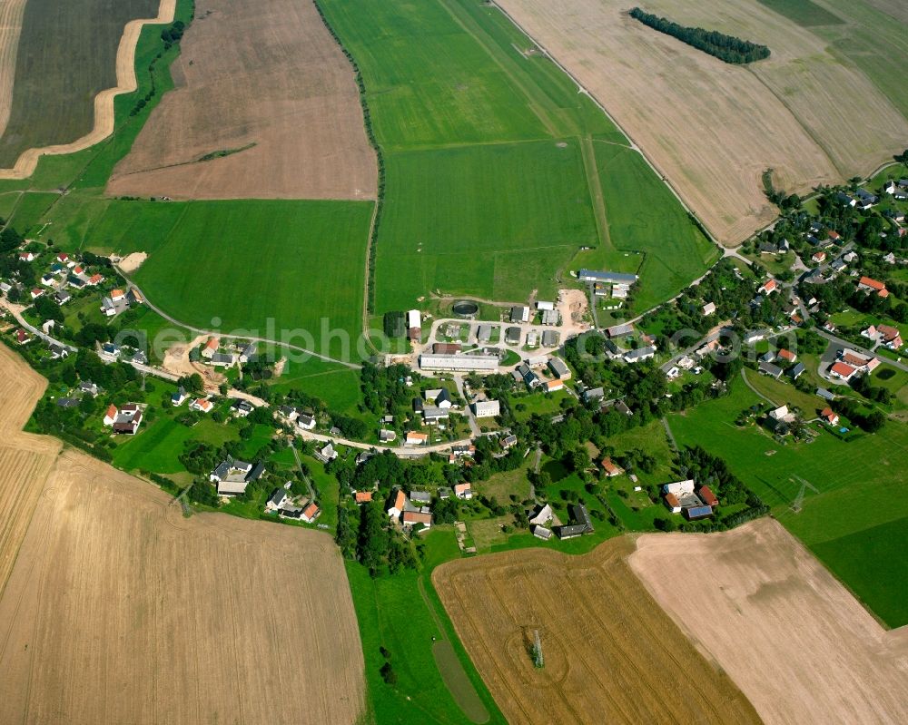 Langhennersdorf from the bird's eye view: Agricultural land and field boundaries surround the settlement area of the village in Langhennersdorf in the state Saxony, Germany