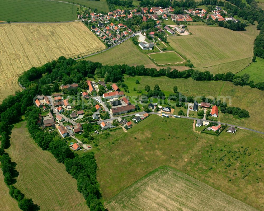 Lenz from above - Agricultural land and field boundaries surround the settlement area of the village in Lenz in the state Saxony, Germany
