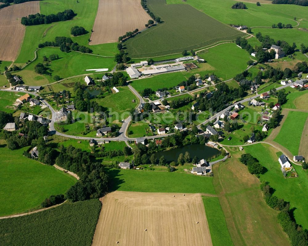 Müdisdorf from the bird's eye view: Agricultural land and field boundaries surround the settlement area of the village in Müdisdorf in the state Saxony, Germany