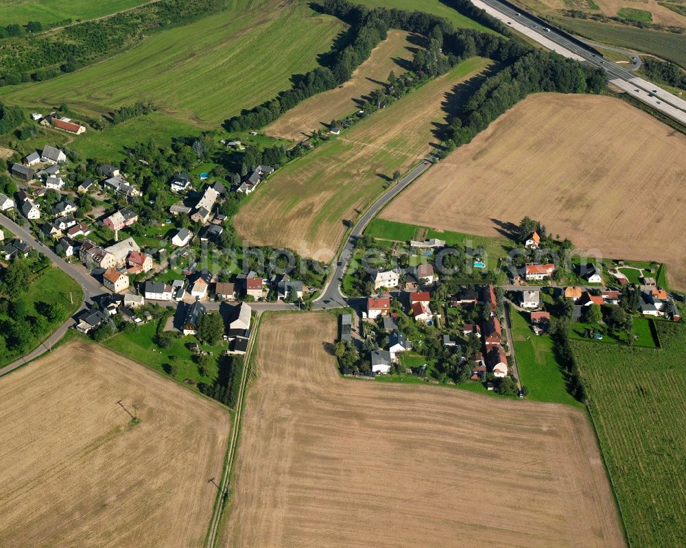 Merzdorf from above - Agricultural land and field boundaries surround the settlement area of the village in Merzdorf in the state Saxony, Germany