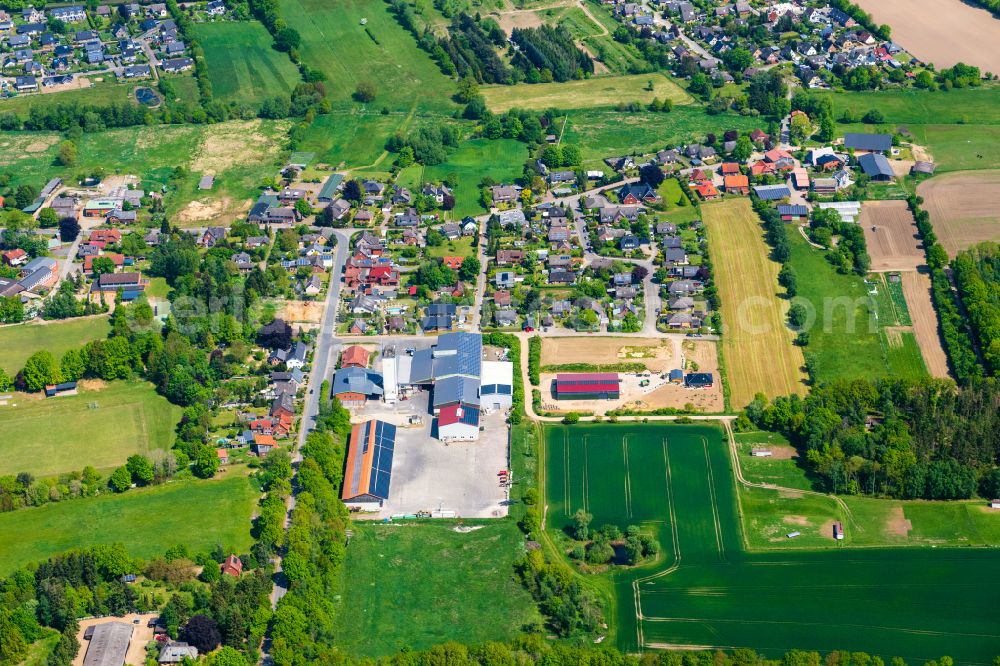 Aerial photograph Müssen - Agricultural land and field boundaries surround the settlement area of the village in Muessen in the state Schleswig-Holstein, Germany