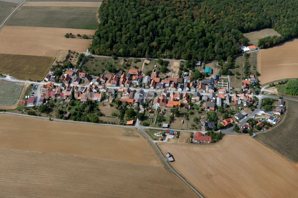 Neubessingen from above - Agricultural land and field boundaries surround the settlement area of the village in Neubessingen in the state Bavaria, Germany