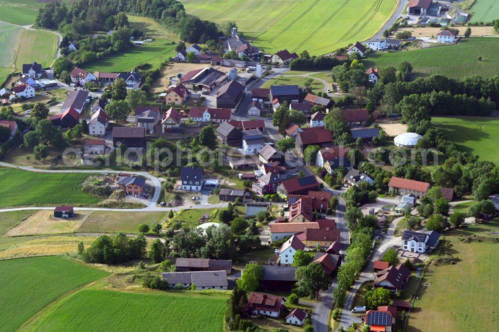 Neuhof from above - Agricultural land and field boundaries surround the settlement area of the village in Neuhof in the state Bavaria, Germany