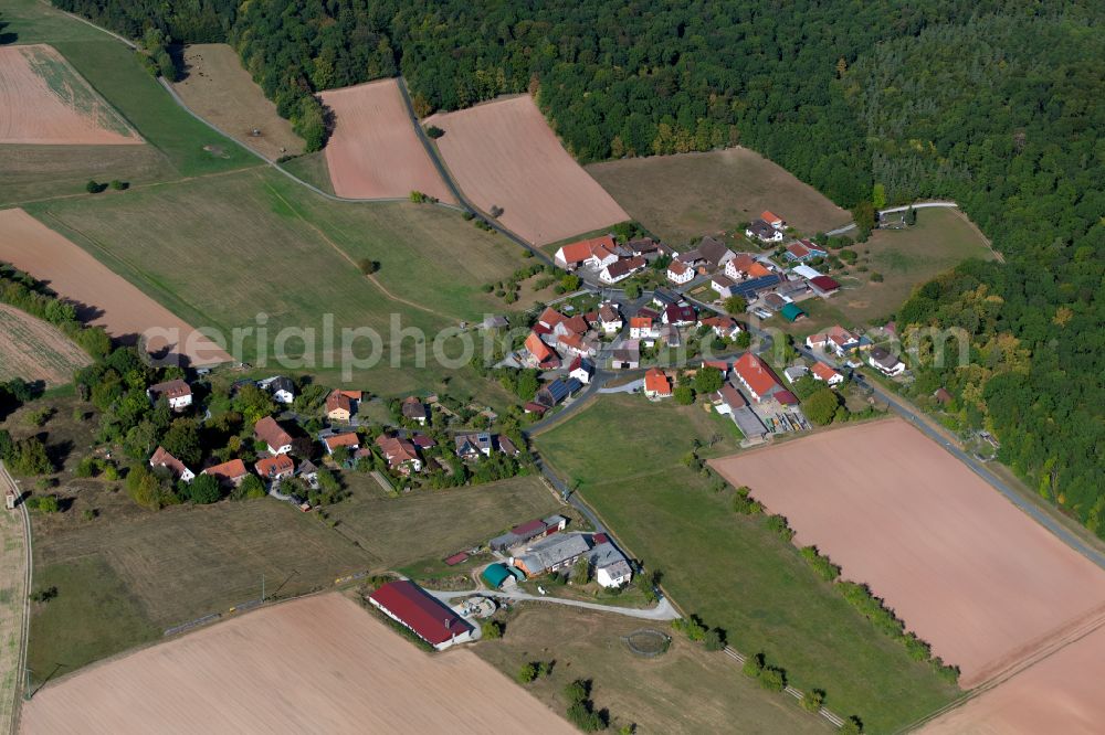 Aerial photograph Neutzenbrunn - Agricultural land and field boundaries surround the settlement area of the village in Neutzenbrunn in the state Bavaria, Germany