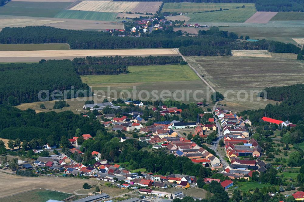 Nichel from the bird's eye view: Agricultural land and field boundaries surround the settlement area of the village in Nichel in the state Brandenburg, Germany