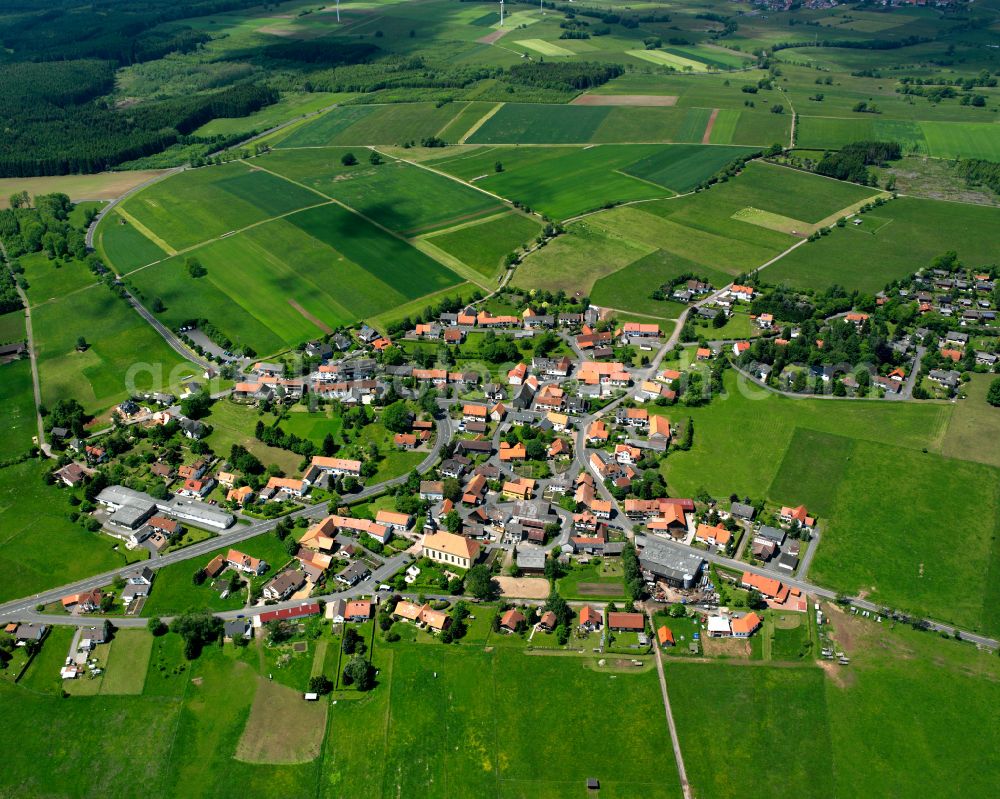 Nieder-Moos from above - Agricultural land and field boundaries surround the settlement area of the village in Nieder-Moos in the state Hesse, Germany