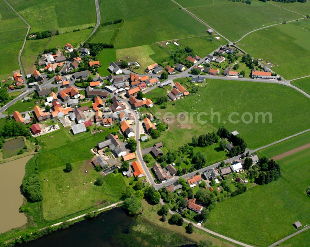 Aerial image Ober-Moos - Agricultural land and field boundaries surround the settlement area of the village in Ober-Moos in the state Hesse, Germany