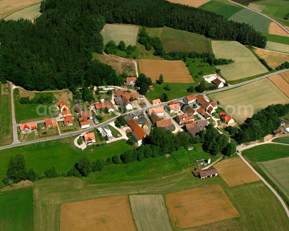 Rückersdorf from the bird's eye view: Agricultural land and field boundaries surround the settlement area of the village in Rückersdorf in the state Bavaria, Germany