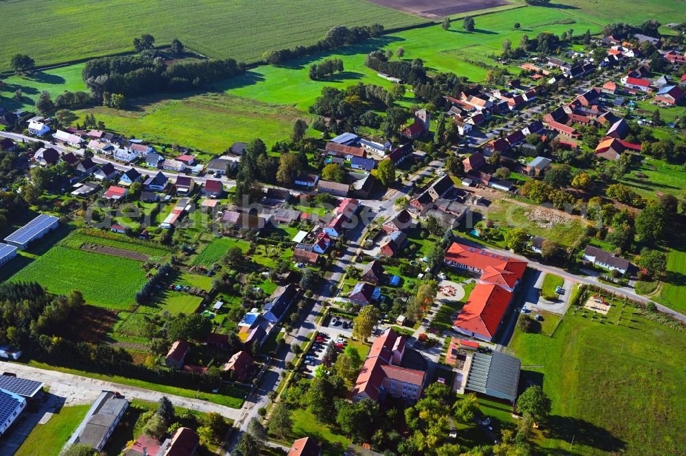 Sadenbeck from the bird's eye view: Agricultural land and field boundaries surround the settlement area of the village in Sadenbeck in the state Brandenburg, Germany