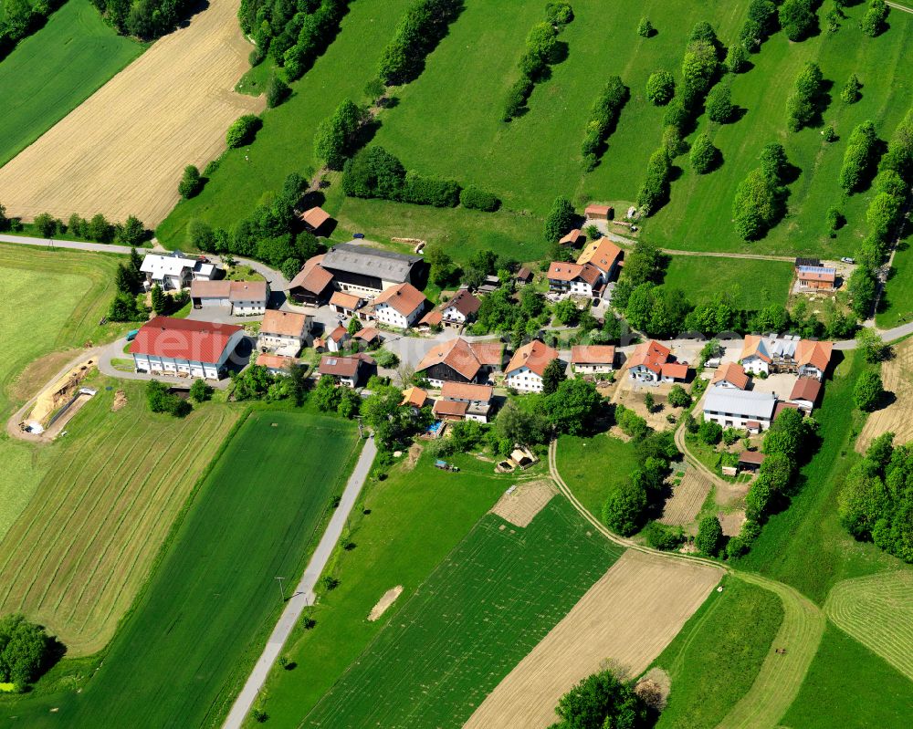 Schlößbach from above - Agricultural land and field boundaries surround the settlement area of the village in Schlößbach in the state Bavaria, Germany