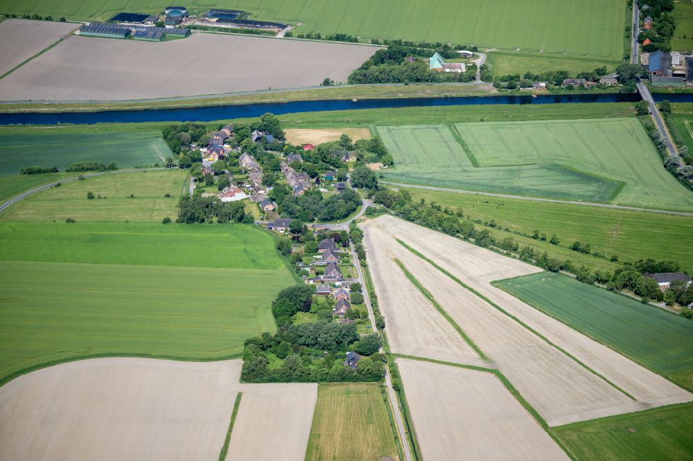 Aerial photograph Dagebüll - Agricultural land and field boundaries surround the settlement area of the village Sueder-Waygaart in Dagebuell North Friesland in the state Schleswig-Holstein, Germany