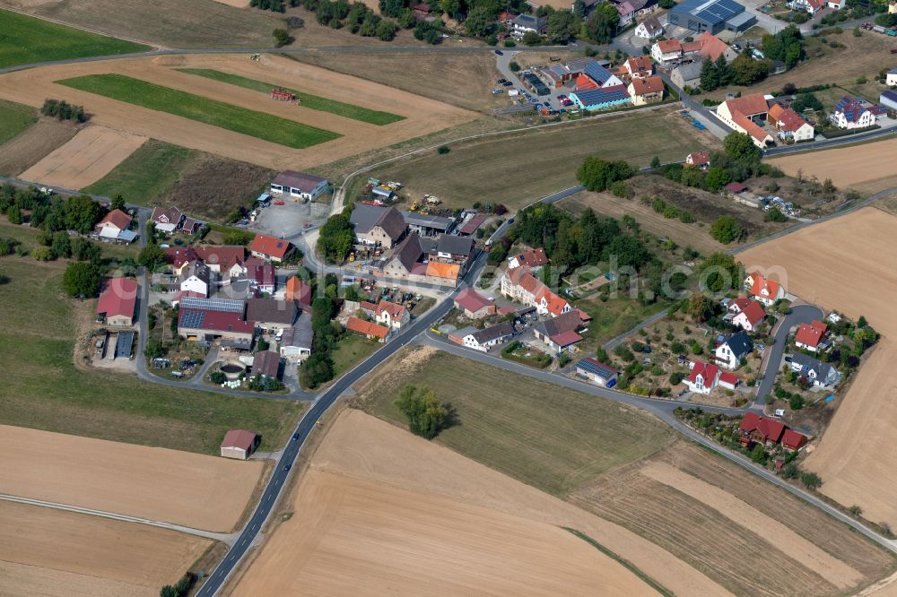 Stadelhofen from above - Agricultural land and field boundaries surround the settlement area of the village in Stadelhofen at Fränkische Schweiz in the state Bavaria, Germany
