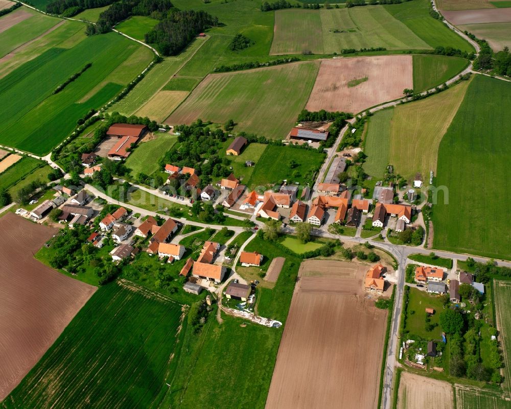 Steinersdorf from above - Agricultural land and field boundaries surround the settlement area of the village in Steinersdorf in the state Bavaria, Germany