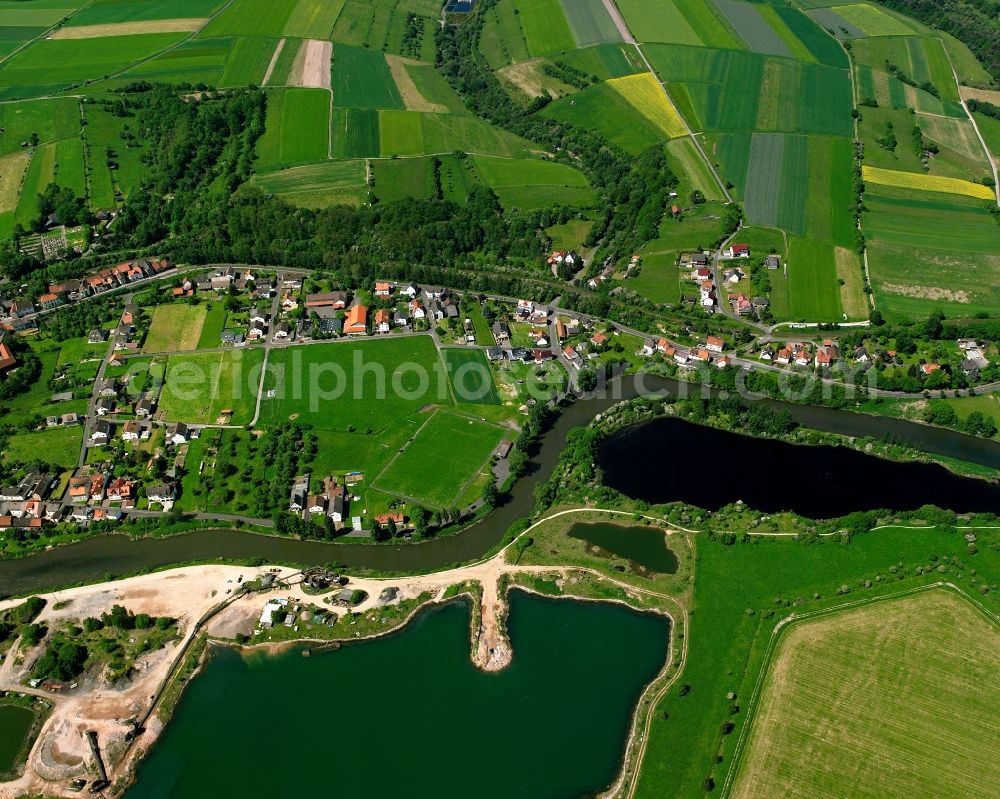 Widdershausen from the bird's eye view: Agricultural land and field boundaries surround the settlement area of the village in Widdershausen in the state Hesse, Germany