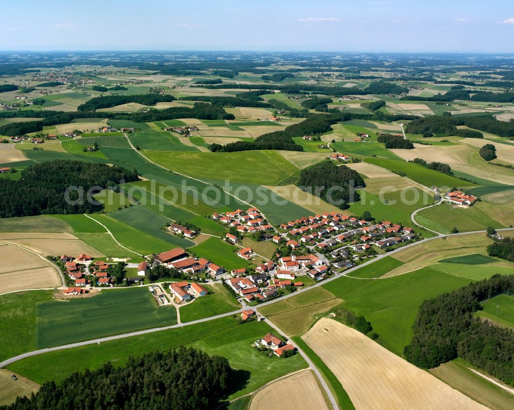 Wolfsberg from the bird's eye view: Agricultural land and field boundaries surround the settlement area of the village in Wolfsberg in the state Bavaria, Germany