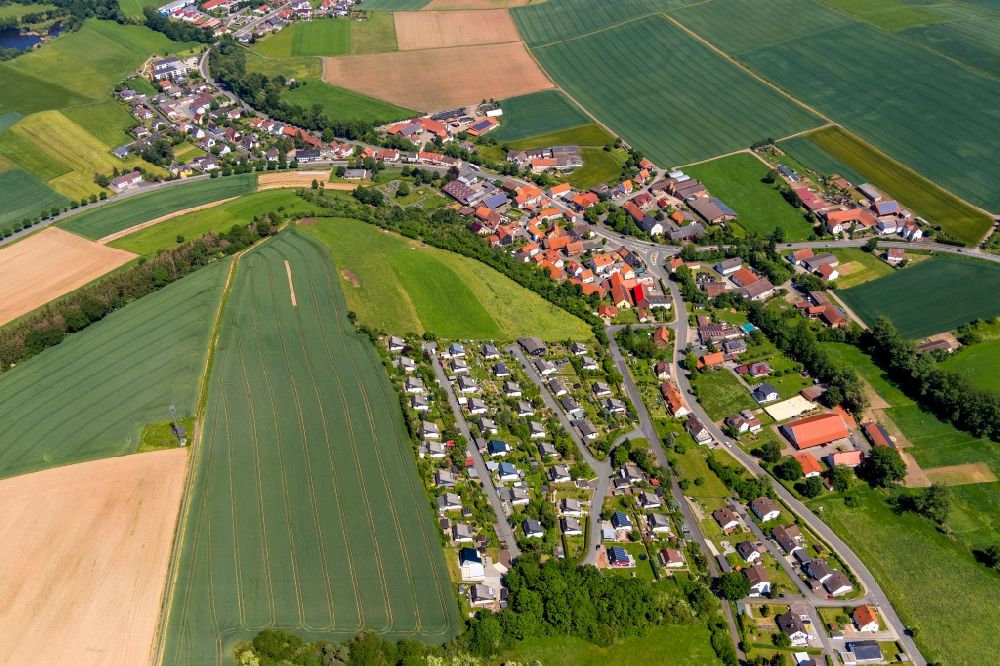 Giflitz from above - Agricultural land and field borders surround the settlement area of the village in Giflitz in the state Hesse, Germany