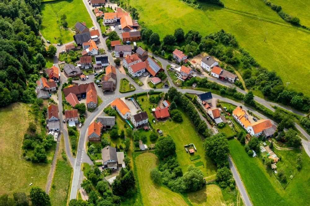 Aerial photograph Hüddingen - Agricultural land and field borders surround the settlement area of the village in Hueddingen in the state Hesse, Germany