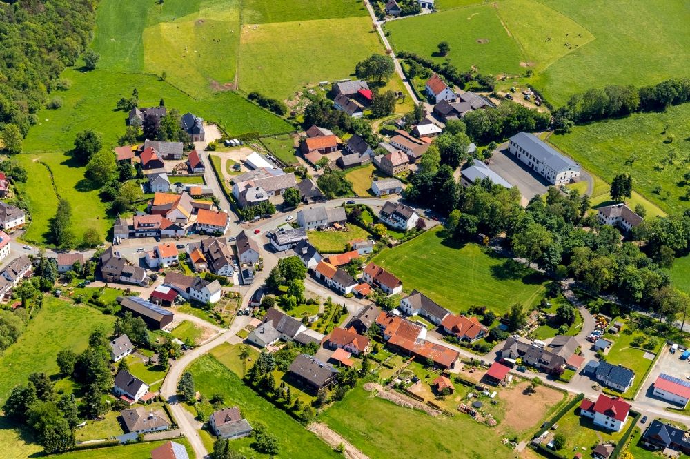 Hillershausen from above - Agricultural land and field borders surround the settlement area of the village in Hillershausen in the state Hesse, Germany