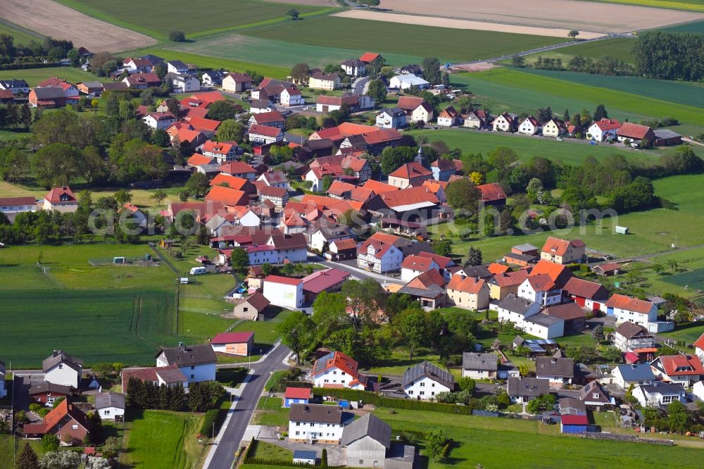 Hilmes from above - Agricultural land and field borders surround the settlement area of the village in Hilmes in the state Hesse, Germany