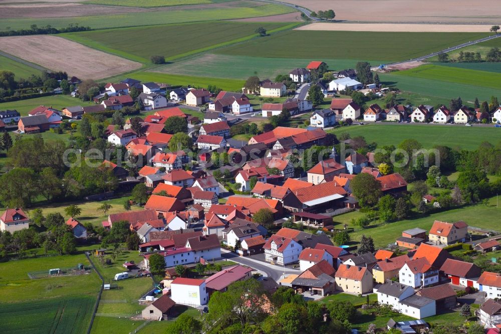 Hilmes from the bird's eye view: Agricultural land and field borders surround the settlement area of the village in Hilmes in the state Hesse, Germany